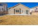 View of the backyard featuring siding and stone detail, plus a grill on the small patio at 22134 Wintergreen Way, Parker, CO 80138