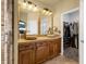 Elegant bathroom featuring double sinks, custom cabinets, and a walk-in closet at 22134 Wintergreen Way, Parker, CO 80138