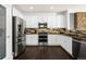 Well-lit kitchen with white cabinets, stainless steel appliances, and a unique backsplash for a modern appeal at 22134 Wintergreen Way, Parker, CO 80138