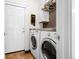 Efficient laundry room with modern washer and dryer, complemented by stylish tile flooring at 22134 Wintergreen Way, Parker, CO 80138