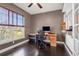 A cozy home office with a dark hardwood floor, a window, a desk and chair, and storage at 22134 Wintergreen Way, Parker, CO 80138