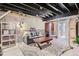 Finished basement with exposed ceiling, accent brick, and decorative area rug at 9492 Crestmore Way, Highlands Ranch, CO 80126