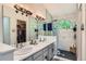 This bathroom features double sinks, black hardware, large mirrors, and a walk-in closet at 9492 Crestmore Way, Highlands Ranch, CO 80126