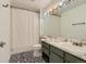 Bathroom featuring decorative tile flooring, a modern vanity, and a shower/tub combo with a white shower curtain at 9492 Crestmore Way, Highlands Ranch, CO 80126