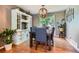 Elegant dining room with wood floors, a statement light fixture, and a vintage storage cabinet at 9492 Crestmore Way, Highlands Ranch, CO 80126