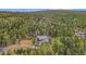 Aerial view showcasing a house's setting in a wooded mountainside at 10518 Christopher Dr, Conifer, CO 80433