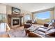 Living room with fireplace, large windows, and comfortable leather seating at 10518 Christopher Dr, Conifer, CO 80433