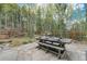 Outdoor patio with stone table, benches, and wooded views at 10518 Christopher Dr, Conifer, CO 80433