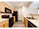 Modern kitchen with wood cabinets and black appliances at 5255 Memphis St # 917, Denver, CO 80239