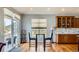 Cozy breakfast nook with wood floors, window and sliding doors to the deck with sunlight streaming in at 6642 S Routt St, Littleton, CO 80127