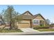 Charming home featuring stone accents, an attached two-car garage, and a well-maintained landscaped front yard at 6642 S Routt St, Littleton, CO 80127
