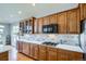 Kitchen with custom wood cabinetry, light countertops, and stainless steel appliances at 6642 S Routt St, Littleton, CO 80127
