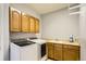 Practical laundry room with modern washer and dryer, ample cabinetry, and counter space at 6642 S Routt St, Littleton, CO 80127
