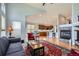 Open-concept living area with a fireplace, comfortable seating, and seamless flow into the kitchen at 6642 S Routt St, Littleton, CO 80127