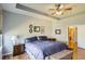 Spacious primary bedroom suite with tray ceilings, ceiling fan, wood floors and ensuite bathroom at 6642 S Routt St, Littleton, CO 80127