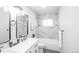 Bright bathroom featuring a tub with marble surround and a modern vanity with black hardware at 8511 Cherry Ln, Westminster, CO 80031