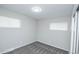 Simple bedroom with gray carpet, white walls, and two windows providing natural light at 8511 Cherry Ln, Westminster, CO 80031