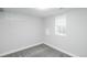 A view of a bedroom with white walls and trim, with neutral-colored carpet and a window for natural light at 8511 Cherry Ln, Westminster, CO 80031