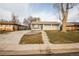 Charming single-story home with a gray front door and concrete steps leading to the landscaped yard at 8511 Cherry Ln, Westminster, CO 80031