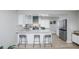 Modern kitchen with an island, bar stools, stainless steel appliances, and white cabinetry at 8511 Cherry Ln, Westminster, CO 80031