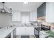 Well-lit kitchen with stainless steel appliances, white cabinetry, modern fixtures, and ample counter space at 8511 Cherry Ln, Westminster, CO 80031