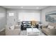 Cozy living room featuring comfortable seating, neutral tones, a large window, and a decorative rug at 8511 Cherry Ln, Westminster, CO 80031