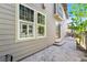 Backyard with stone patio, lush green tree and neutral toned siding at 3332 Valentia St, Denver, CO 80238