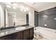 Modern bathroom features a dark vanity, granite countertop, shower, and tub at 3332 Valentia St, Denver, CO 80238