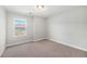 Bright bedroom features neutral carpet, baseboard, and large window at 3332 Valentia St, Denver, CO 80238
