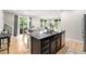 Modern kitchen island with granite countertops, undermount sink, and views of the dining and living areas at 3332 Valentia St, Denver, CO 80238