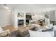 Open-concept living room showcasing a fireplace, hardwood floors, and seamless flow to the kitchen at 3332 Valentia St, Denver, CO 80238