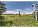 Large and expansive backyard featuring lush green grass and beautiful landscaping at 41975 Muirfield Loop, Elizabeth, CO 80107