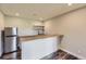 Basement bar area with sleek countertops, stainless steel appliances, and floating shelves at 41975 Muirfield Loop, Elizabeth, CO 80107