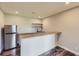 Finished basement with a countertop bar and stainless steel refrigerator at 41975 Muirfield Loop, Elizabeth, CO 80107