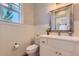 Half bathroom with a white vanity, stylish mirror, and classic wainscotting at 41975 Muirfield Loop, Elizabeth, CO 80107