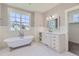 Bathroom with a soaking tub, marble counters, white cabinets, and wainscotting at 41975 Muirfield Loop, Elizabeth, CO 80107