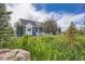 Charming blue two-story home with white trim, front porch, and lush green surroundings at 41975 Muirfield Loop, Elizabeth, CO 80107