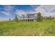 Blue house with a well-kept backyard, set against a clear blue sky with scattered clouds at 41975 Muirfield Loop, Elizabeth, CO 80107