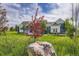 Blue home with stone accents, white trim, large windows, and lush green lawn at 41975 Muirfield Loop, Elizabeth, CO 80107