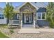 Charming front porch with stone accents, stylish lighting, and decorative plants at 41975 Muirfield Loop, Elizabeth, CO 80107
