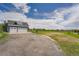 Exterior view of the three car garage with an asphalt driveway and expansive yard at 41975 Muirfield Loop, Elizabeth, CO 80107