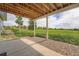 Covered patio area showcasing a concrete foundation and gravel, with views of a grassy field at 41975 Muirfield Loop, Elizabeth, CO 80107