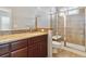 Elegant bathroom featuring a glass-enclosed shower, wood vanity, and tiled walls at 5895 S Taft Ct # H, Littleton, CO 80127