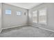 Bright bedroom featuring plush gray carpeting and multiple windows providing ample natural light at 5895 S Taft Ct # H, Littleton, CO 80127