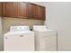 Functional laundry room featuring a washer, dryer, and overhead cabinetry for storage at 5895 S Taft Ct # H, Littleton, CO 80127