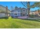 A spacious, grassy backyard with mature trees, a patio, and fencing for privacy at 7877 S Ulster St, Centennial, CO 80112
