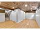 Spacious basement with wood-paneled ceiling, wood-look flooring, and ample storage space at 7877 S Ulster St, Centennial, CO 80112