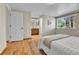 Bright bedroom showcasing hardwood floors and a window with a view, leading to an ensuite bathroom at 7877 S Ulster St, Centennial, CO 80112