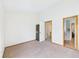 Empty bedroom showcasing neutral carpet and doorway to another room at 2007 S Balsam St, Lakewood, CO 80227