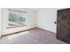 Carpeted bedroom featuring a window with natural light and a wooden closet at 2007 S Balsam St, Lakewood, CO 80227